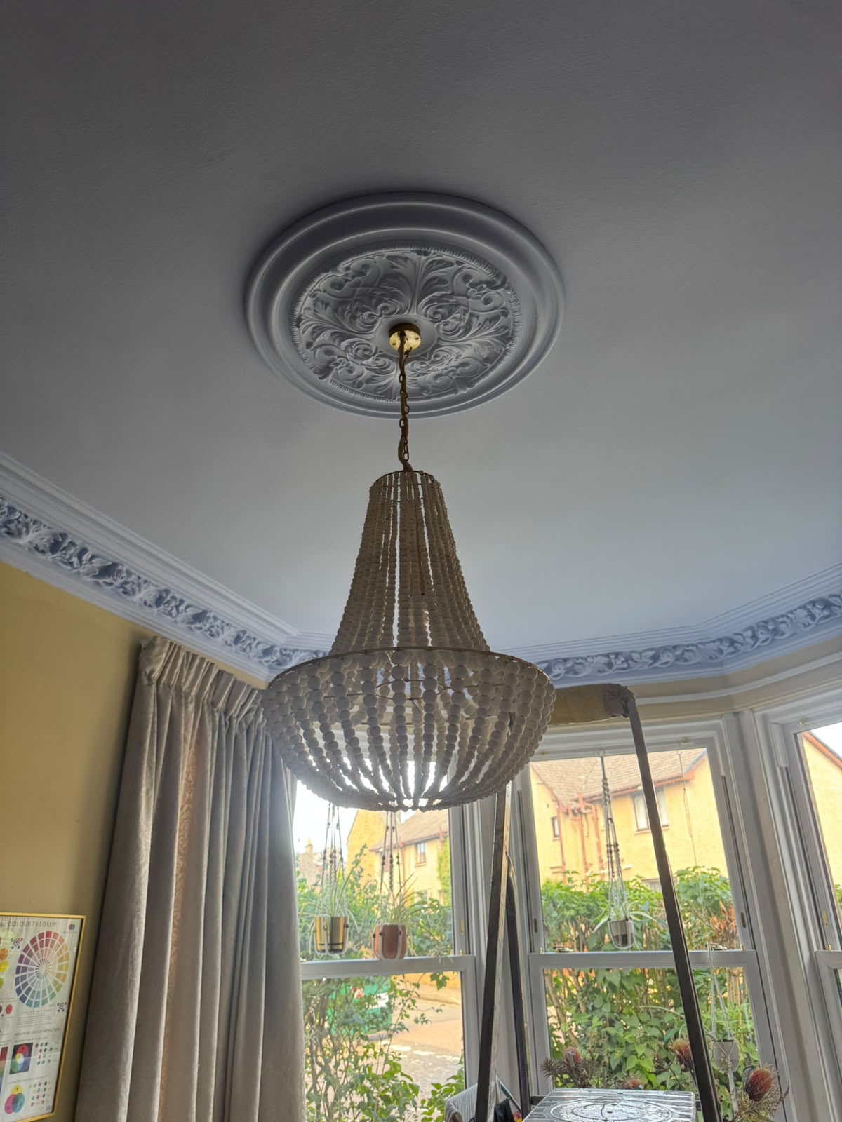 Decorative ceiling rose with chandelier pendant in a period living room