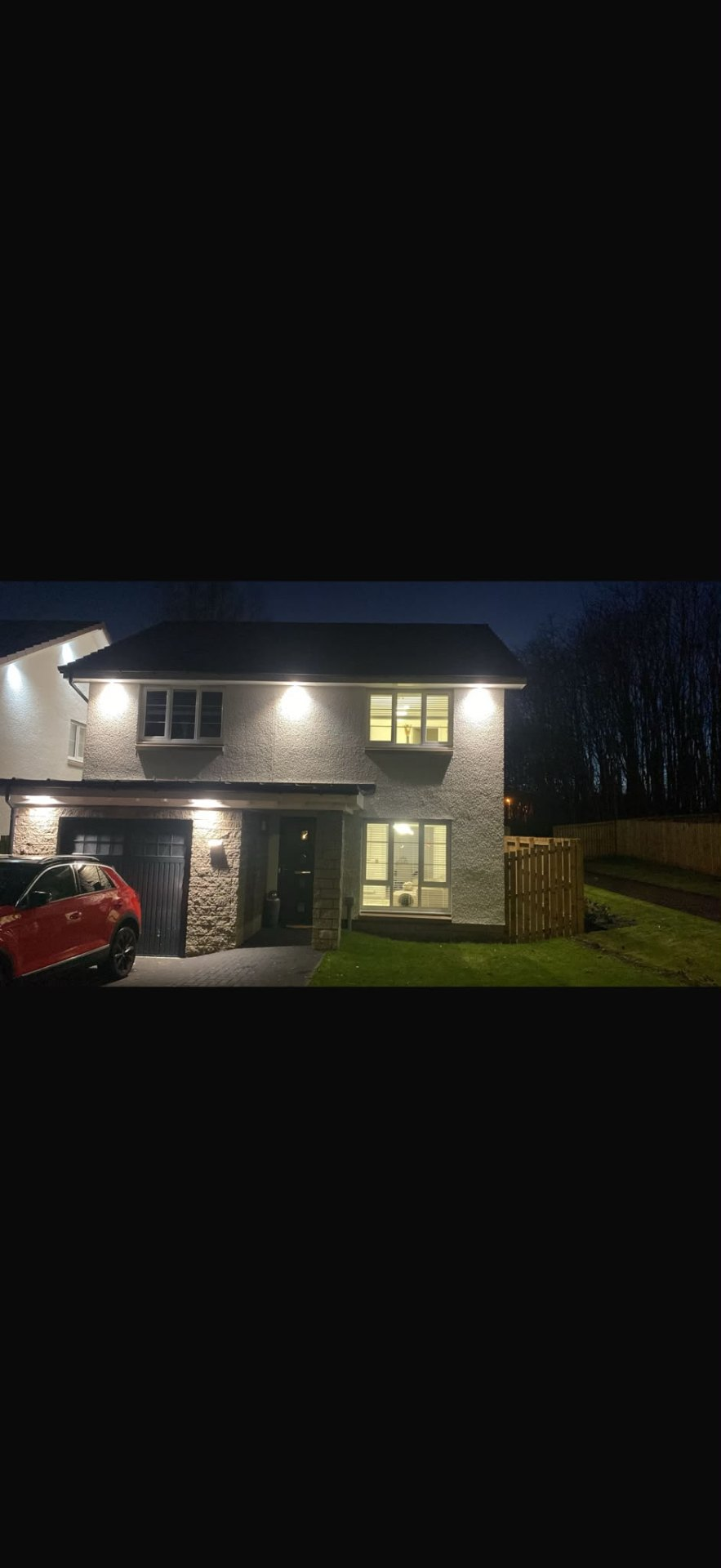 Soffit lighting installation illuminating a modern home exterior at night